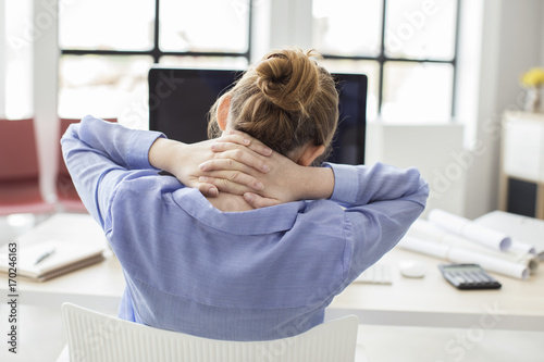 Foto  Tired businesswoman holding her nape