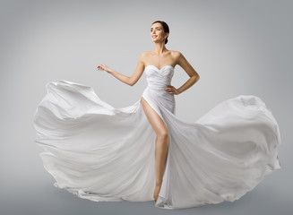 woman white dress, fashion model bride in long silk wedding gown, elegant flying fabric, fluttering 