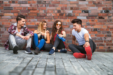 Group of young friends sitting on street and talking