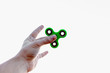 Close up of a man's hand who is holding green fidget spinner