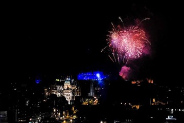 fireworks over edinburgh castle with view of the city. finale of edinburgh international festival in