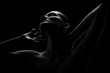 © tugolukof - aroused woman posing sensually holding head up on black background, monochrome