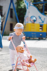  girl playing with stroller  and doll