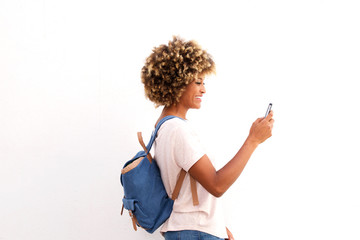 Wall Mural - Side portrait of african american female looking at smart phone against white background