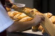 Mulher escolhendo pão francês para o café da manha 