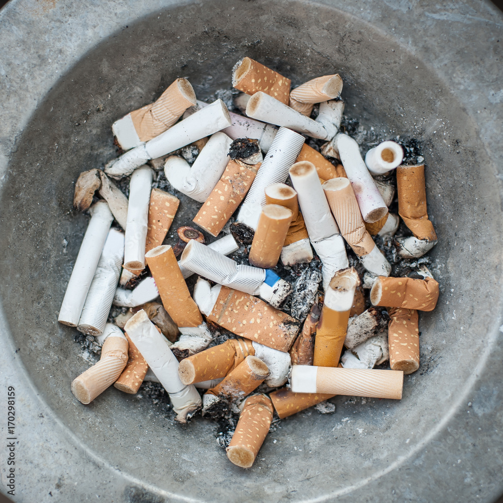 eating ashes from cigarettes Ashtray full of cigarettes butt and ashes. Real life scene Stock Photo