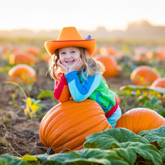 child playing on pumpkin patch