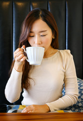 Asian woman drinking coffee