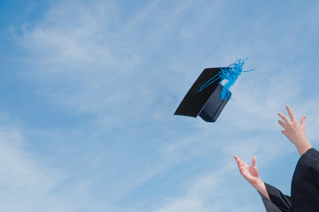 Graduate success celebration throw graduation cap in the sky concept background with copy space