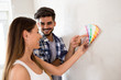 © didesign - Young happy couple choosing colors for painting their home