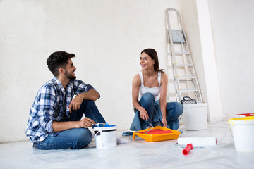 Lovely smiling happy couple painting new home