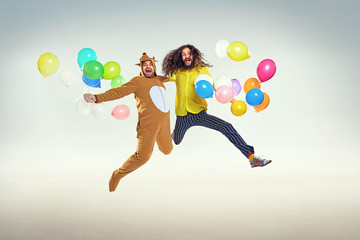 Wall Mural - Picture presenting two funny guys jumping and holding balloons