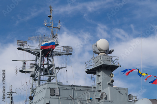 Plakat Najwyższa część wielkiego pancernika wojskowego z wieżami, masztami, flagami kolorowania i antenami