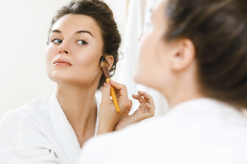 Wall Mural - Woman applying foundation or blusher on her face