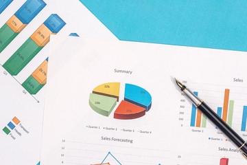 business graph, diagram and report with pen on blue