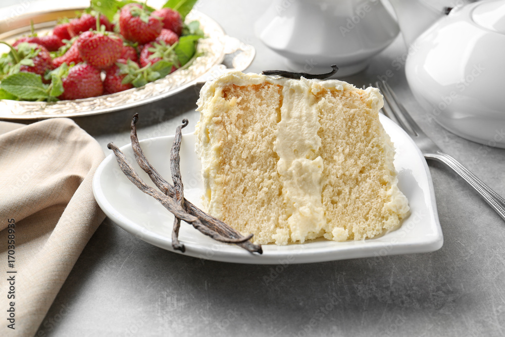 Piece of delicious vanilla cake on table