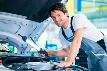 Wall Mural - Auto mechanic working in car service workshop working