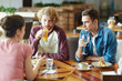 © pressmaster - Group of college students talking at lunch break in cafe after classes