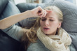 © Alina - Young woman is laying down on the coach and holding her head