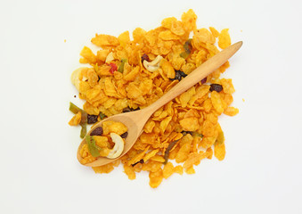 cereal with cashew nut and kiwi in a wooden spoon against pile of cereal with cashew nut and kiwi on white background.