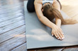 © Liubov Levytska - Close up of hands doing yoga or pilates laying on a grey mat in a temple or a backyard.