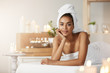 © Cookie Studio - Portrait of beautiful african girl with towel on head smiling resting in spa salon.