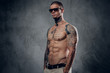 © Fxquadro - Muscular, shirtless, tattooed male over grey background.