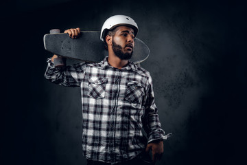 Wall Mural - A man holds long board over grey background in a studio.