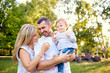 © Studio Romantic - Happy family in a park in summer autumn. Mother, father and baby play in nature in the rays of sunset.