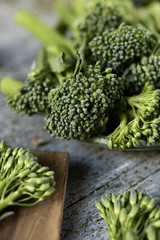 Wall Mural - stems of raw broccolini on a rustic table