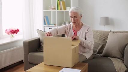 Wall Mural - senior woman opening parcel box at home