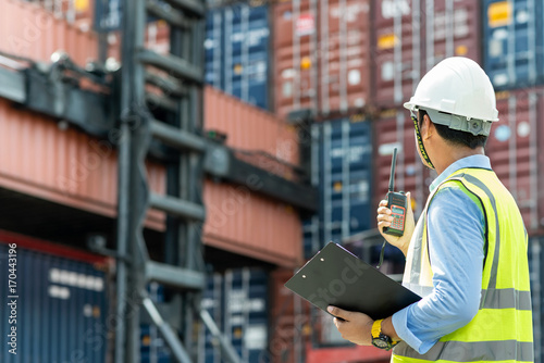 Fotografía Foreman control loading Containers box from Cargo freight ship for import export
