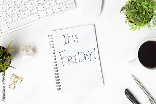 Poster The notebook with Friday motivation text is on top of white office desk table