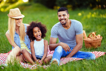 Wall Mural - Picture of lovely couple with their daughter having picnic