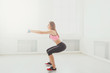 © Prostock-studio - Young beautiful woman in sportswear doing squat