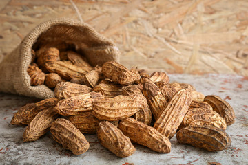 Wall Mural - Raw peanut in hemp sack on wooden background