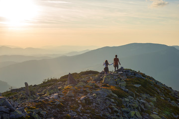 teenagers boy and a girl walk along a stony mountain range