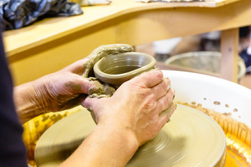 A pottery. Master on the circle makes a vase of clay.