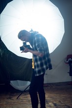 Photographer Photographing While Standing By Strobe Light