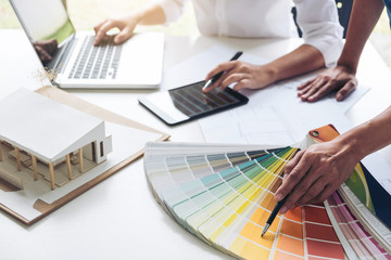 Poster - Two interior design or graphic designer at work on project of architecture drawing with work tools and color swatches, colour chart, color samples for selection, renovation and technology concept