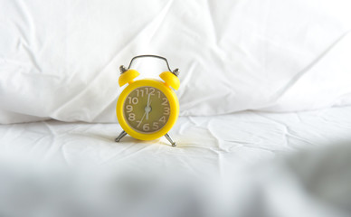 Wall Mural - Yellow Alarm clock on bed in morning with sun light