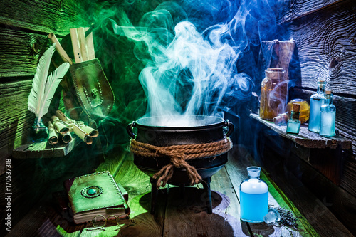 Foto Vintage witcher cauldron with magic potions and books for Halloween