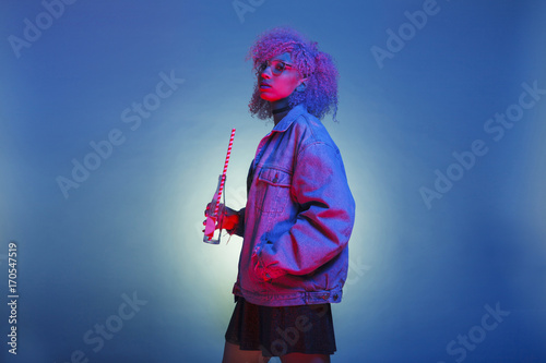 Fotografie, Obraz vintage black woman with trendy clothes drinking a soda on neon lights