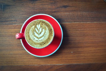 Wall Mural - red  cup of hot coffee on wooden table in coffee shop,red cup