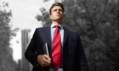 Poster - Composite image of low angle view of businessman holding digital