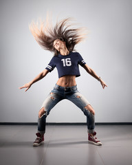 Wall Mural - modern young beautiful dancer posing on a studio background