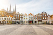 View on the beautiful buildings facades and church on the central square during the sunny morning in Delft city, Netherland