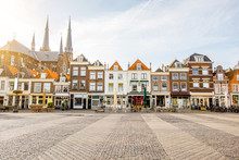 View On The Beautiful Buildings Facades And Church On The Central Square During The Sunny Morning In Delft City, Netherland