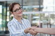 © theartofpics - Business woman shaking hands in the office. Business meeting. Customer service. Hospitality concept.