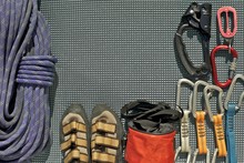 Rock Climbing Equipment Laid Out On A Grey Mat. Rope, Climbing Shoes, Chalk Back, Quickdraws Belay/rappel Device With Carabiner And Ascender. 